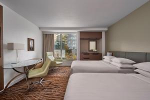 Pokój hotelowy z 2 łóżkami i biurkiem w obiekcie Melbourne Marriott Hotel w Melbourne