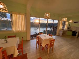 a dining room with a table and chairs and a large window at Avista al Rio in Puerto Iguazú