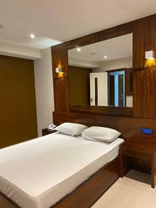 um quarto com uma grande cama branca e um espelho em Verona Hotel no Rio de Janeiro