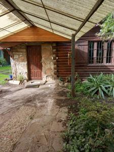 ein Haus mit einer Holztür und einer Veranda in der Unterkunft Mystic House in Mar del Plata