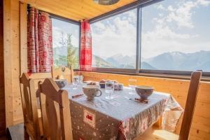 a table in a room with a large window at Apartment with a superb view in l'Alpe d'Huez - Welkeys in LʼHuez