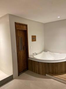 a large bath tub in a room with a wooden door at Verona Hotel in Rio de Janeiro