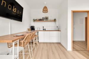 una cucina con bancone e tavolo in una stanza di nobar - Innenstadt-Apartment - Smart-TV - Kaffee - Netflix a Wernigerode