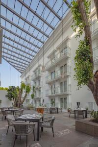 un patio con mesas y sillas y un edificio en Presidente Intercontinental Puebla, an IHG Hotel, en Puebla