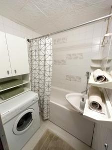 y baño con lavadora y lavamanos. en Apartmán Simcity 2 en Banská Bystrica