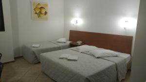 a bedroom with two beds with towels on them at Hotel Plaza Sul in Caràzinho