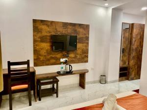a room with a desk and a television on a wall at Hotel Haridwar in Haridwār