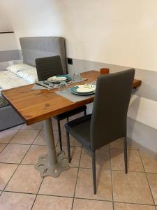 a dining room table with two chairs and a table with plates on it at CASA VACANZA PIEVE in Pisogne