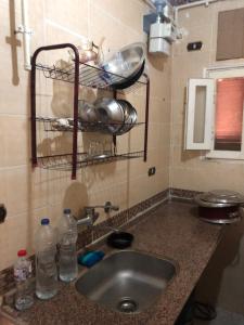 a kitchen counter with a sink and water bottles at شقة مصيفية بدمياط الجديدة قريبة من الشاطئ والخدمات in Dumyāţ al Jadīdah