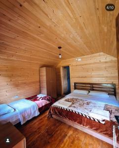 a bedroom with two beds in a wooden cabin at Hotel Tradita Valbonë in Valbonë