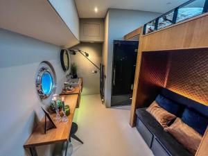 Habitación pequeña con sofá y espejo. en Boat & Boost Amsterdam, en Ámsterdam