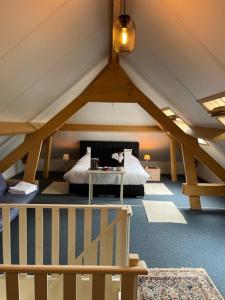 a attic room with a bed and a table at Villa Haagdoorn te Achel, 10 personen, 12 personen op aanvraag, met zwembad op het zuiden in een oase van rust! in Achel