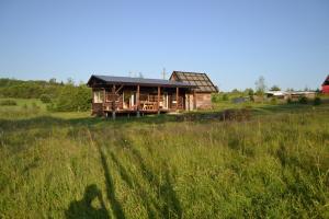 una casa de madera en un campo de hierba alta en bieszczadzki holender, en Lipie