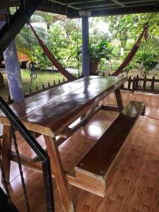 una mesa de madera en un porche con un columpio en La Mochis, en Puerto Jiménez