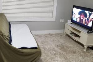 ein Wohnzimmer mit einem Flachbild-TV und einem Sofa in der Unterkunft Basement Suite 1 queen bedroom(Brand New House) in Coquitlam