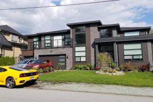 ein gelbes Auto, das vor einem Haus parkt in der Unterkunft Basement Suite 1 queen bedroom(Brand New House) in Coquitlam