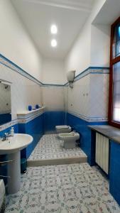 un bagno blu e bianco con due servizi igienici e un lavandino di casacapasso a Napoli