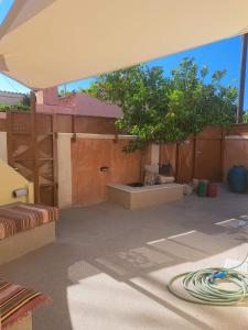 a patio with a tree and a white umbrella at Castle luxury home in Chios