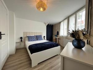 a bedroom with a bed with blue pillows on it at Gîte Au Coeur d’Azay in Azay-le-Rideau