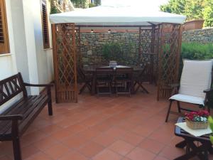 un patio con mesa, sillas y una sombrilla blanca en Villa Giuliana, en San Vito lo Capo