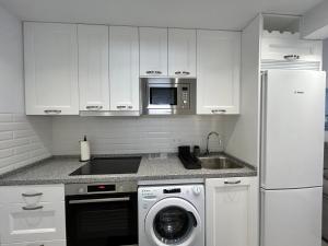 eine Küche mit einer Waschmaschine und einer Mikrowelle in der Unterkunft Mare Apartments Marbella in Marbella