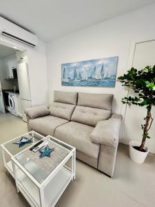 ein Wohnzimmer mit einem Sofa und einem Tisch in der Unterkunft Mare Apartments Marbella in Marbella