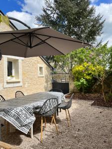 a table and chairs with an umbrella on a patio at Gîte Au Coeur d’Azay in Azay-le-Rideau