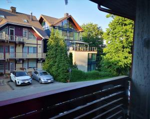 two cars parked in a parking lot in front of a building at Good Vibes :) in Juodkrantė