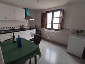 a kitchen with a green table and a window at Alojamiento Oviedo 2 con parking in Oviedo +14 photos