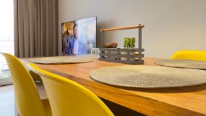 a long wooden table with yellow chairs around it at Departamento moderno en Rosario calidad & ubicación in Rosario