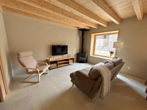 a living room with a couch and a chair and a television at CAL GALL rural Cerdanya in Bellver de Cerdanya