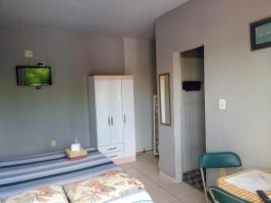 a bedroom with two beds and a tv on the wall at Residencial Andréa House in Manaus