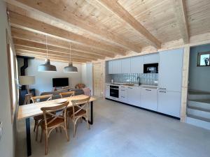 a kitchen and dining room with a wooden ceiling at CAL GALL rural Cerdanya in Bellver de Cerdanya