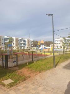 een park met een hek en een speeltuin bij Résidence flambant neuve 5min à pied de la plage in Saidia 