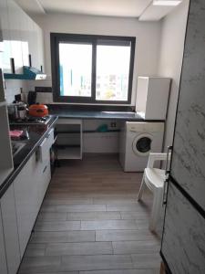 een kleine keuken met een raam en een wasmachine bij Résidence flambant neuve 5min à pied de la plage in Saidia 
