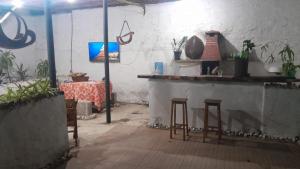 a room with a table and stools and a table with plants at Pousada Rainha das Águas in Ilhéus