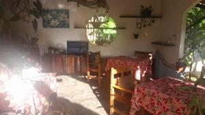 a dining room with two tables and a chandelier at Pousada Rainha das Águas in Ilhéus