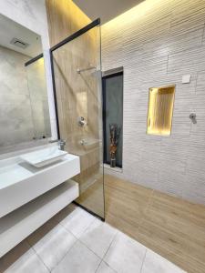 a bathroom with a sink and a glass shower at Skylight chalet in Nizwa