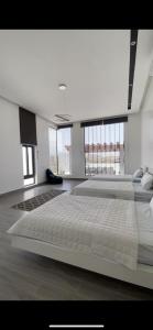 a large bed in a room with large windows at Skylight chalet in Nizwa