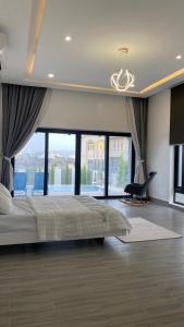 a bedroom with a large bed and a large window at Skylight chalet in Nizwa