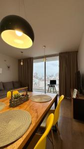 a living room with a table and yellow chairs at Departamento moderno en Rosario calidad & ubicación in Rosario