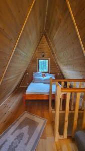 a bedroom with a bed in a wooden attic at Doka Valea Sebesului A-Frame in Sebeşu +56 photos