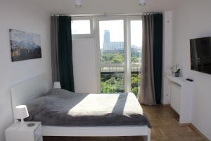 a bedroom with a bed and a large window at Strict center Warsaw comfortable apartment, 10th-floor with beautiful view on the park and skyscrapers, free WiFi, self check-in/out in Warsaw