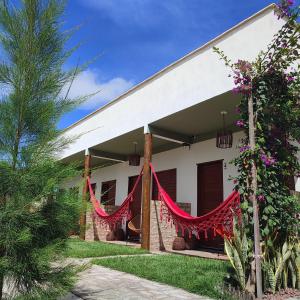 una casa con cortinas rojas fuera de ella en De Ventto Em Popa - São Miguel do Gostoso RN, en São Miguel do Gostoso