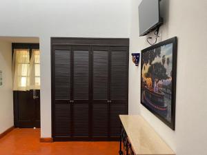 a large wooden door with a television on a wall at Casa Yollotzin in Ajijic
