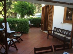 un patio con sillas, mesa y bancos en Villa Giuliana, en San Vito lo Capo