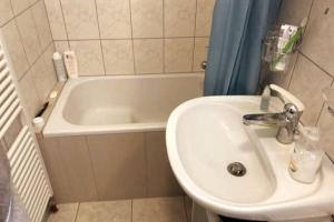 a bathroom with a sink and a bath tub at Charmante maison individuelle in Les Verrières