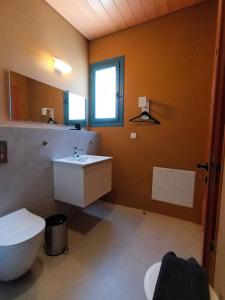uma casa de banho com um lavatório branco e um WC. em Apartment Rustico em Ancient Epidavros