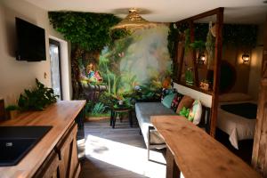 a living room with a large painting on the wall at Le Mas de la Pouzolle - Gîtes et chambre atypiques in Le Garn