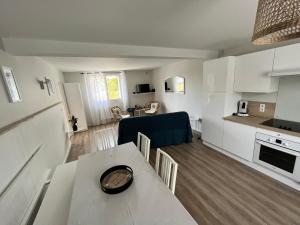 a kitchen and a living room with a table and chairs at Gîte Au Coeur d’Azay in Azay-le-Rideau